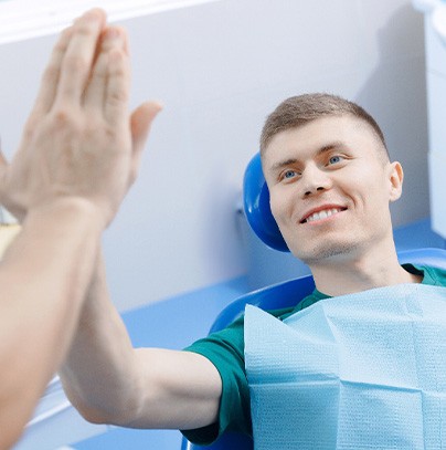 Patient high-fiving dentist after procedure