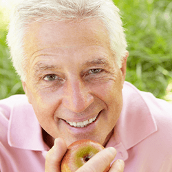 Man smiles before eating apple