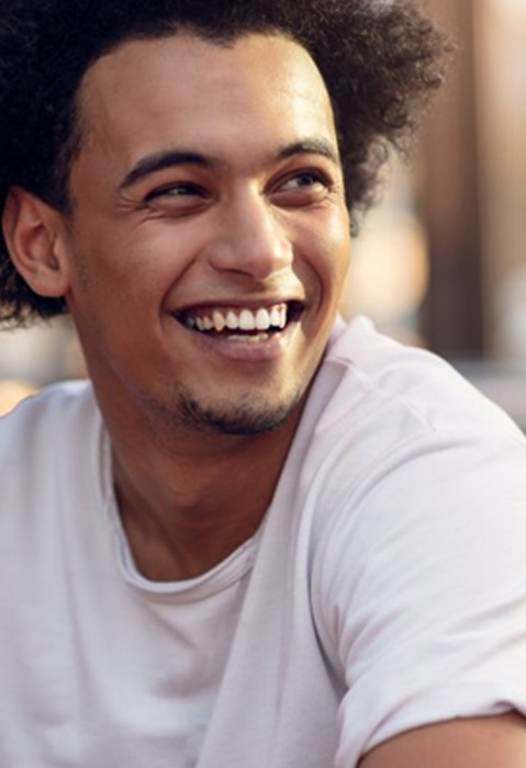 Young man grinning after gum recontouring in Garland
