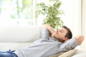 Young man relaxing on couch after dental crown treatment